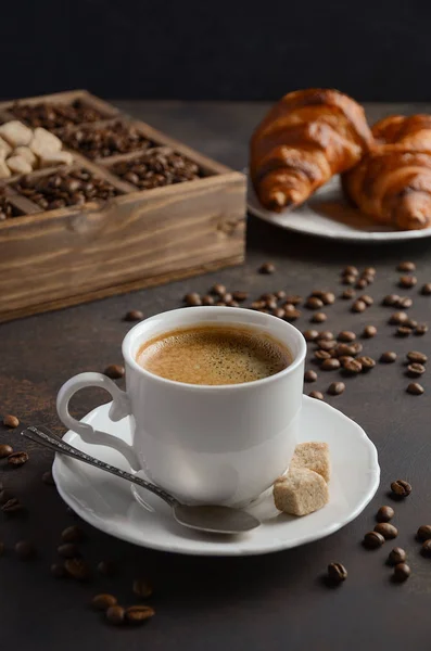 Tasse frischen Kaffee mit Croissants auf dunklem Hintergrund — Stockfoto