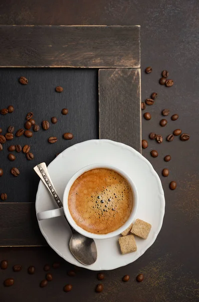 Tasse frischen Kaffee mit Kaffeebohnen auf dunklem Hintergrund — Stockfoto