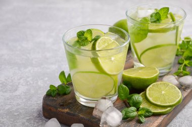 Soğuk Yaz içeceği kireç ve gri beton veya taş zemin üzerine bir bardak nane ile yenileme.