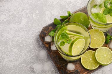 Soğuk Yaz içeceği kireç ve gri beton veya taş zemin üzerine bir bardak nane ile yenileme