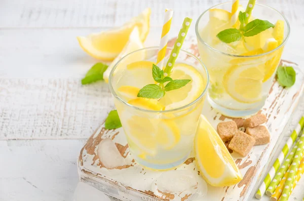 Minuman musim panas yang menyegarkan dengan lemon dan mint di latar belakang kayu . — Stok Foto