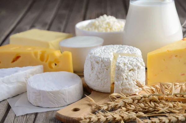 Produtos lácteos frescos. Leite, queijo, brie, Camembert, manteiga, iogurte, queijo cottage e ovos em mesa de madeira . — Fotografia de Stock