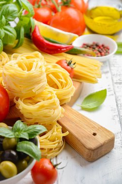 Makarna, sebzeler, otlar ve baharatlar Beyaz ahşap zemin üzerinde İtalyan gıda için