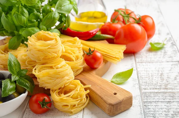 Pasta, Gemüse, Kräuter und Gewürze für italienische Küche auf weißem Holzgrund — Stockfoto