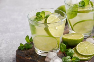 Soğuk Yaz içeceği kireç ve gri beton veya taş zemin üzerine bir bardak nane ile yenileme.