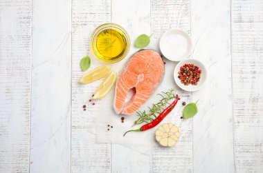 Limon, zeytin yağı ve baharat rustik ahşap zemin üzerine taze Çiğ somon biftek. Sağlıklı yemek yapmak için malzemeler. Sağlıklı beslenme kavramı.