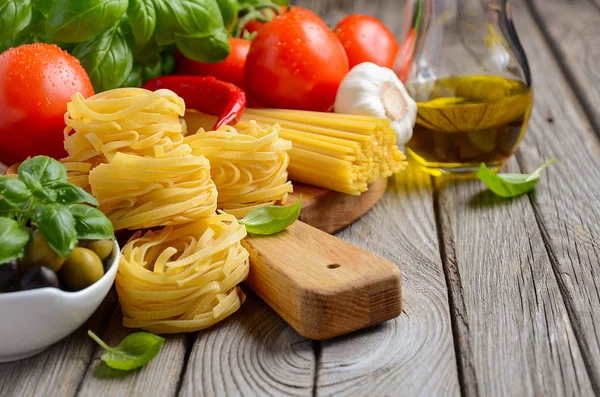 Pasta, Gemüse, Kräuter und Gewürze für italienische Speisen auf Holzgrund — Stockfoto