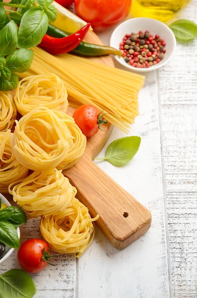 Pasta, Gemüse, Kräuter und Gewürze für italienische Speisen auf Holzgrund — Stockfoto