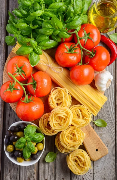 Pasta, groenten, kruiden en specerijen voor Italiaans eten op houten achtergrond — Stockfoto