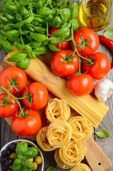 Pasta, vegetables, herbs and spices for Italian food on wooden background — Stock Photo, Image