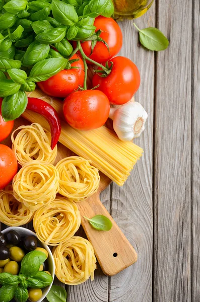 Pasta, vegetables, herbs and spices for Italian food on wooden background — Stock Photo, Image