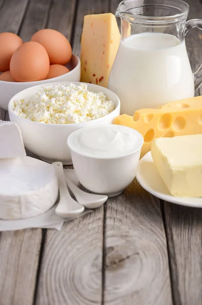 Свежие молочные продукты. Молоко, сыр, бри, камамбер, масло, йогурт, творог и яйца на деревянном столе . — стоковое фото