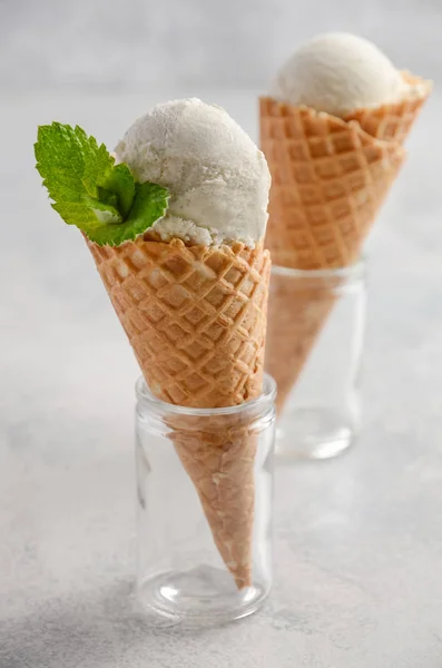 Ванильное мороженое в вафельном рожке на сером бетонном фоне — стоковое фото