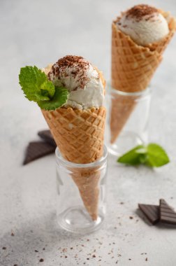 Vanilyalı dondurma waffle koni ile gri beton zemin üzerine çikolata kırıntı