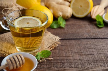 Zencefil kök çay limon ve bal ahşap arka plan üzerinde