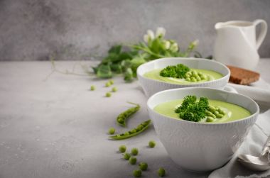 Kase gri beton veya taş zemin üzerine yeşil bezelye çorbası