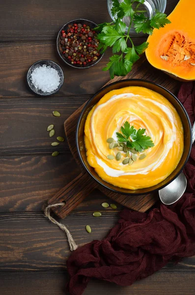 Ahşap arka plan üzerinde krem ve kabak çekirdeği ile kabak kremalı çorba