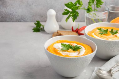 Krem ve maydanoz bir gri beton veya taş arka plan ile kabak çorbası