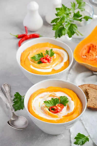 Soupe de citrouille à la crème et au persil sur fond de béton gris ou de pierre — Photo