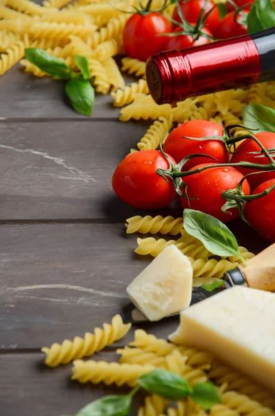 Comida italiana - fusilli cru, tomate, manjericão, queijo e vinho na mesa de madeira — Fotografia de Stock