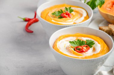 Krem ve gri beton veya taş zemin üzerine maydanoz ile kabak çorbası.