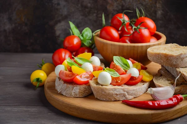 Bruschetta with cherry tomatoes and mozzarella. — Stock Photo, Image