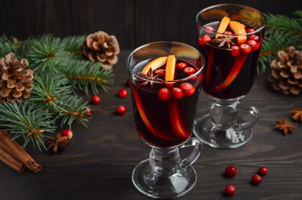 Vánoční svařené víno. Dovolená concept zdobené s větvemi jedlí, brusinkami a koření. — Stock fotografie
