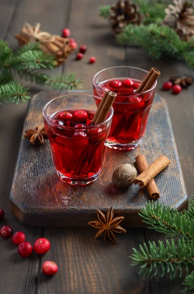 Kızılcık içki çam dalları, baharat ve taze çilek ile dekore edilmiş ahşap arka plan üzerinde.