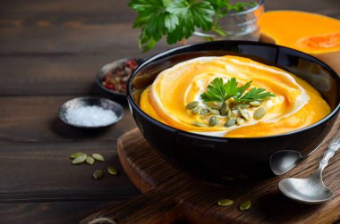 Ahşap arka plan üzerinde krem ve kabak çekirdeği ile kabak kremalı çorba