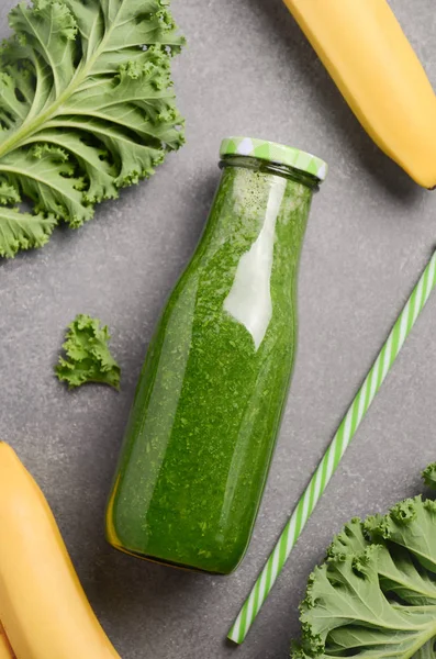 Batido verde fresco con col rizada y plátano en una botella . — Foto de Stock