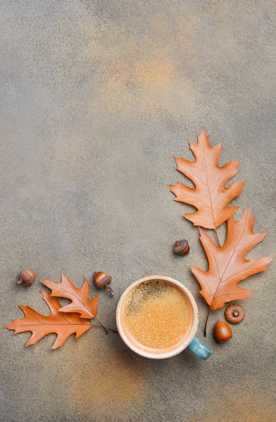 Осенняя композиция с чашкой кофе и осенними листьями на каменном или бетонном фоне — стоковое фото