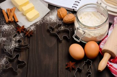 Malzemeler - çerez kesiciler, baharat, tereyağı, yumurta ve un koyu ahşap arka plan üzerinde pişirme Noel