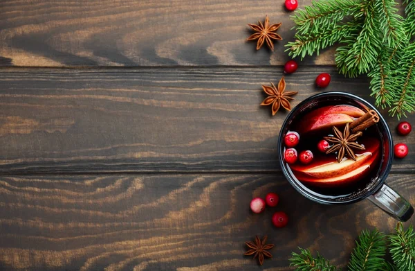 Рождественское вино с яблоками и клюквой. Концепция праздника украшена елочными ветвями, клюквой и пряностями . — стоковое фото