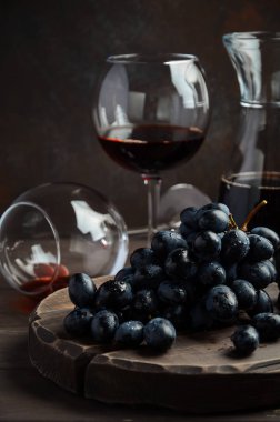 Taze siyah üzüm ve ahşap masa üzerinde kırmızı şarap
