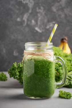 Kale ve bir kavanoz muz ile taze yeşil smoothie.