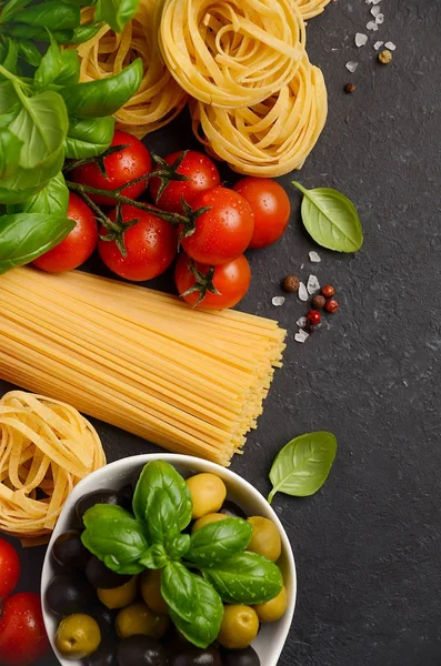Pasta, groenten, kruiden en specerijen voor Italiaanse gerechten op zwarte achtergrond. — Stockfoto