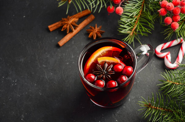 Christmas Mulled Wine with Orange and Cranberries. Holiday Concept Decorated with Fir Branches and Spices. Selective focus, copy space.