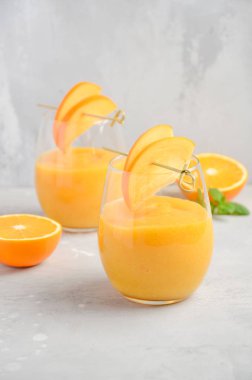 Trabzon hurması, turuncu ve gri beton zemin üzerine zencefil taze sağlıklı güler yüzlü. Seçici odak.