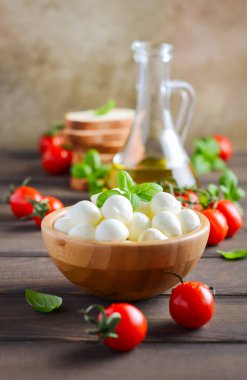İtalyan yemeği malzemeler Mozzarella peyniri, domates, fesleğen ve zeytinyağı rustik ahşap tablo.