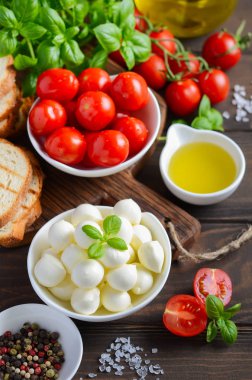 İtalyan yemeği malzemeler Mozzarella peyniri, domates, fesleğen ve zeytinyağı rustik ahşap tablo.