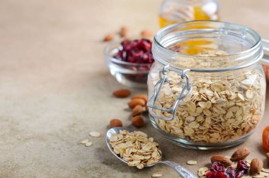 Ev yapımı yulaf ezmesi granola için malzemeler. Yulaf gevreği, bal, badem fındık, kurutulmuş cranberries ve kayısı. Sağlıklı kahvaltı konsepti.