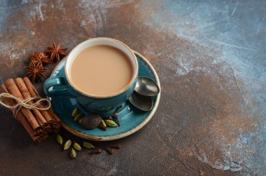 Hint masala chai çay. Karanlık paslı zemin üzerine sütlü baharatlı çay. Seçici odak, kopya alanı.