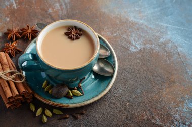 Hint masala chai çay. Karanlık paslı zemin üzerine sütlü baharatlı çay. Seçici odak, kopya alanı.