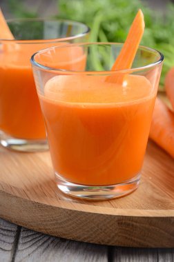 Ahşap zemin üzerinde taze havuç suyu.