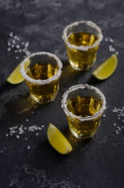 Kireç ve karanlık taş veya beton arka plan, seçici odak tuz RIM ile altın tekila