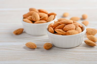 Badem bir kase Beyaz ahşap arka planda, seçici odak alanı kopyalayın.