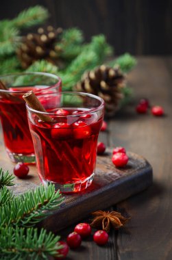 Kızılcık içki çam dalları, baharat ve taze çilek ile dekore edilmiş ahşap arka plan üzerinde.