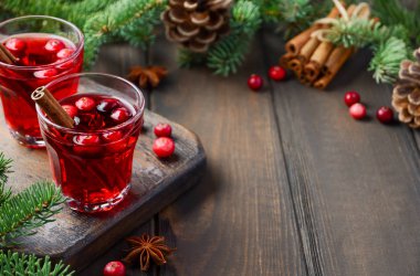 Kızılcık içki çam dalları, baharat ve taze çilek ile dekore edilmiş ahşap arka plan üzerinde.