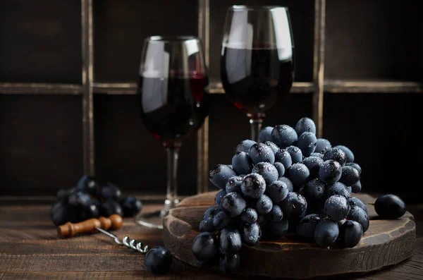Fresh Black Grapes and Red Wine on Wooden Table