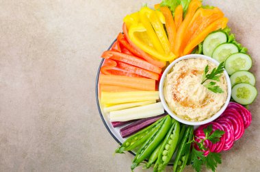 Humus tabağı ve çeşitli sebze atıştırmalıkları. Sağlıklı vejetaryen ve vejetaryen yemekleri. Üst görünüm, düz görünüm, kopyalama alanı.